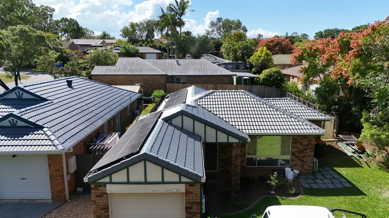Freshly recoated charcoal tile roof under a clear blue Brisbane sky